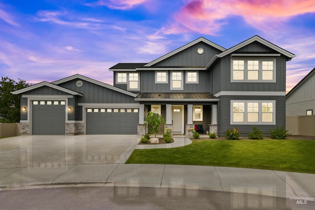 craftsman-style home with covered porch, a standing seam roof, board and batten siding, an attached garage, and a yard