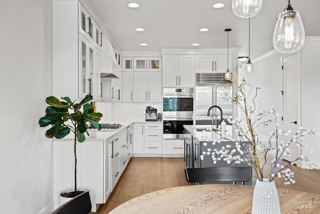 kitchen featuring light countertops, a sink, stainless steel appliances, recessed lighting, and white cabinetry