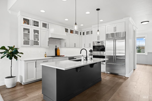 kitchen featuring a sink, light countertops, stainless steel appliances, and dark wood-type flooring