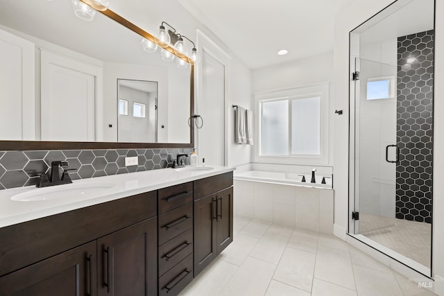 bathroom featuring a sink, backsplash, a shower stall, and a bath