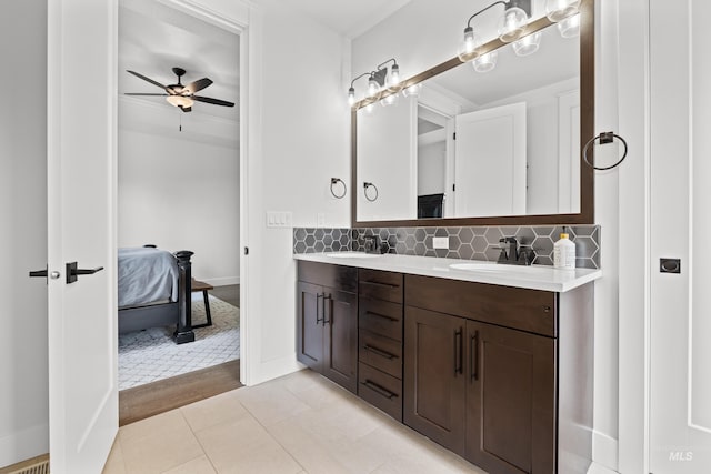 ensuite bathroom with double vanity, a sink, connected bathroom, and a ceiling fan