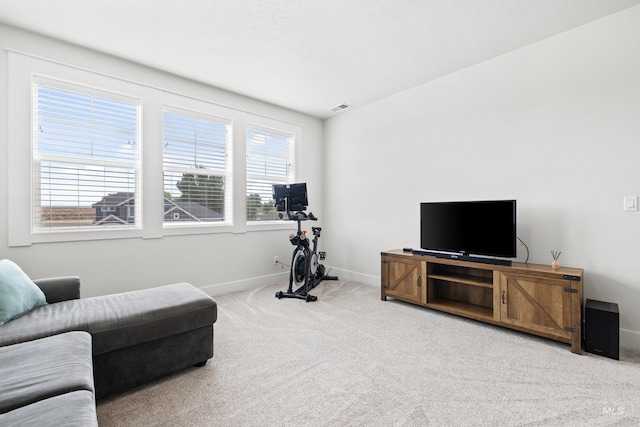 living room with baseboards, visible vents, and light colored carpet