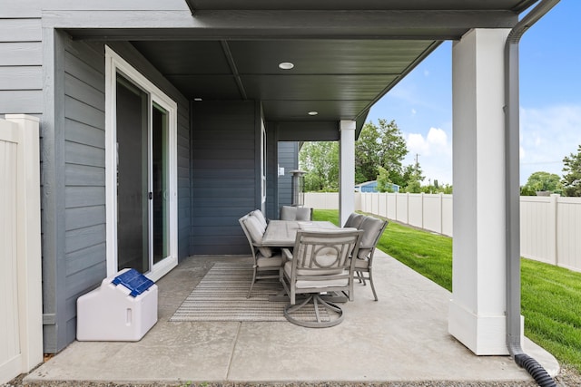 view of patio featuring outdoor dining area and fence