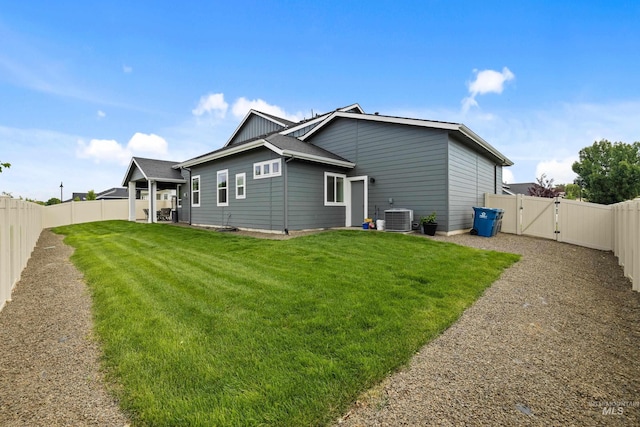 rear view of property with a lawn, a gate, a fenced backyard, and central AC unit
