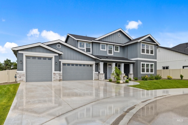 craftsman-style home with fence, a garage, board and batten siding, a front yard, and driveway
