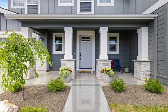property entrance with covered porch and board and batten siding