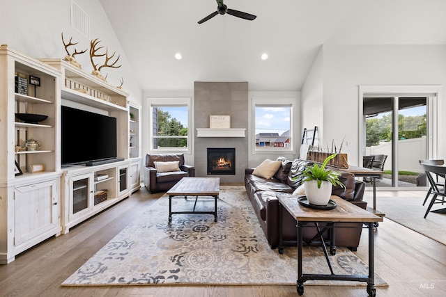 living room with ceiling fan, a fireplace, wood finished floors, and a wealth of natural light