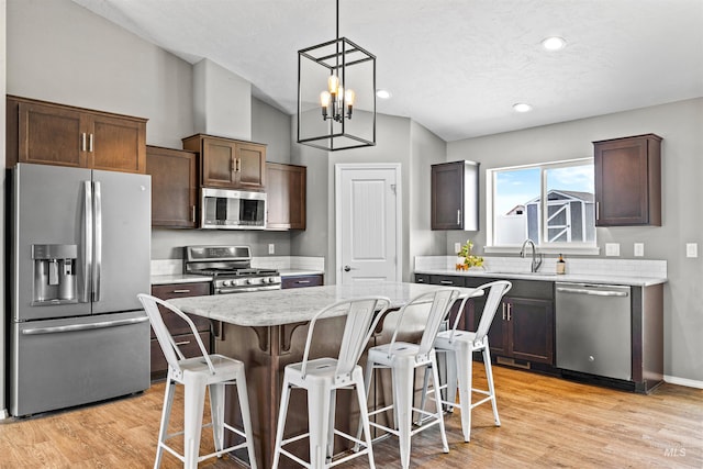 1724 Pioneer Dr, Lewiston, ID 83501 - kitchen featuring appliances with stainless steel finishes, lofted ceiling, a kitchen breakfast bar, a chandelier, and a kitchen island