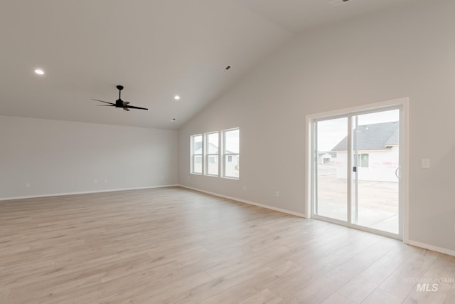 empty room featuring light hardwood / wood-style flooring, high vaulted ceiling, and ceiling fan