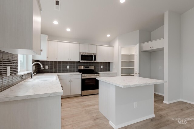 kitchen featuring sink, white cabinetry, stainless steel appliances, and a healthy amount of sunlight