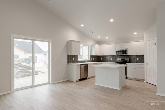 unfurnished room with light hardwood / wood-style flooring, high vaulted ceiling, and ceiling fan