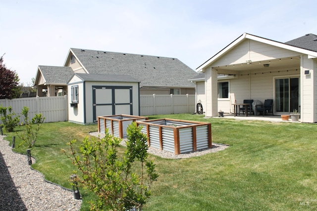 4951 W Torana St, Meridian, ID 83646 - rear view of house featuring a patio area, a vegetable garden, a storage unit, an outbuilding, and roof with shingles