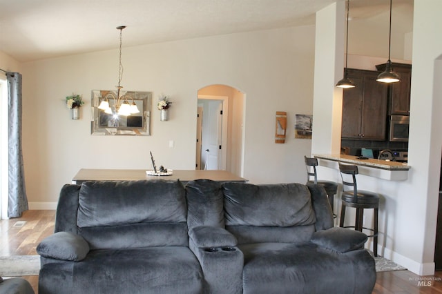 4951 W Torana St, Meridian, ID 83646 - living room with arched walkways, wood finished floors, lofted ceiling, baseboards, and a chandelier