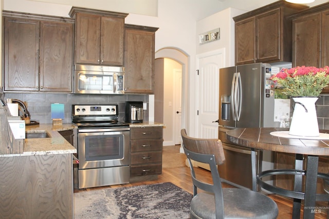 4951 W Torana St, Meridian, ID 83646 - kitchen with stainless steel appliances, a sink, decorative backsplash, and light stone countertops