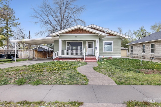 1631 Poplar Ave, Twin Falls, ID 83301 - bungalow-style house featuring a front lawn, fence, covered porch, an attached carport, and concrete driveway