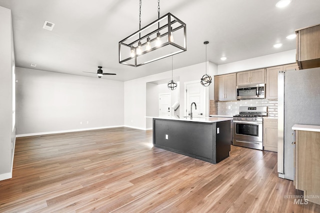 1755 N Crystal Cove Ave, Meridian, ID 83646 - kitchen featuring stainless steel appliances, ceiling fan, light countertops, light wood-style flooring, and backsplash