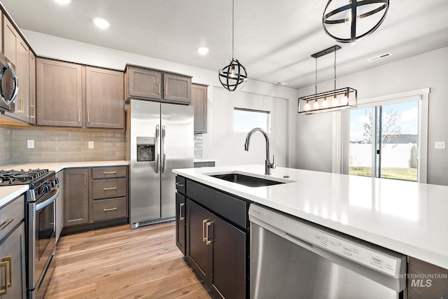 1755 N Crystal Cove Ave, Meridian, ID 83646 - kitchen featuring stainless steel appliances, light countertops, light wood-style floors, recessed lighting, and tasteful backsplash