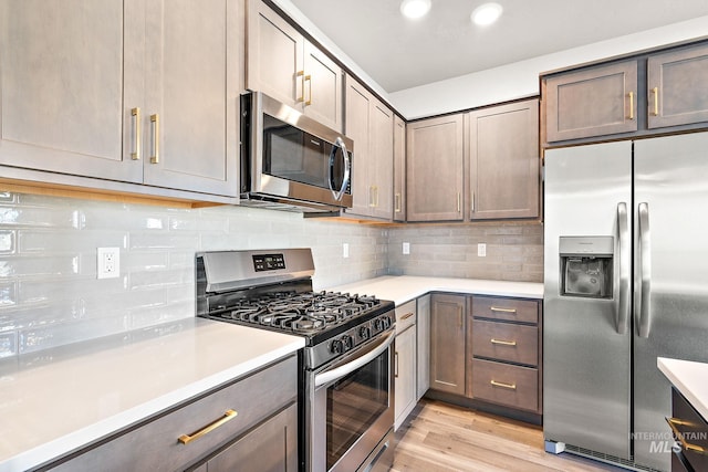 1755 N Crystal Cove Ave, Meridian, ID 83646 - kitchen with appliances with stainless steel finishes, light countertops, light wood-type flooring, decorative backsplash, and recessed lighting