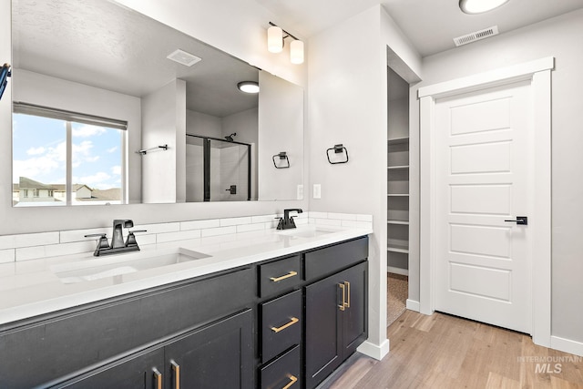 1755 N Crystal Cove Ave, Meridian, ID 83646 - full bathroom featuring a shower stall, wood finished floors, double vanity, and a walk in closet