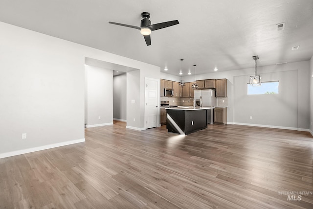 1755 N Crystal Cove Ave, Meridian, ID 83646 - unfurnished living room featuring ceiling fan, light wood finished floors, and recessed lighting