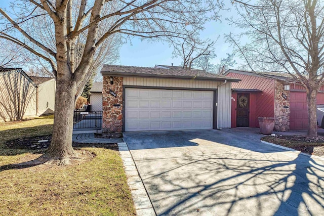 view of front of property with a garage, stone siding, fence, and concrete driveway