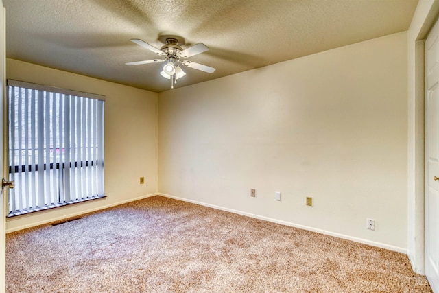 spare room featuring ceiling fan, a textured ceiling, visible vents, and carpet flooring