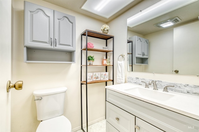 bathroom with visible vents, vanity, and toilet