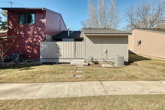 view of property exterior with central air condition unit and a lawn