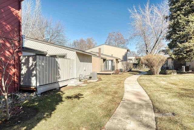 exterior space with central AC unit and a yard