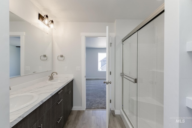 4391 N Magical Creek Ave, Meridian, ID 83646 - bathroom with double vanity, a sink, a stall shower, and wood finished floors