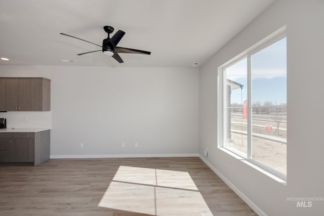 4391 N Magical Creek Ave, Meridian, ID 83646 - unfurnished living room with light wood-style floors, a healthy amount of sunlight, ceiling fan, and baseboards