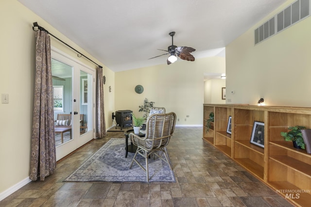 living area featuring stone finish floors, baseboards, french doors, lofted ceiling, and ceiling fan