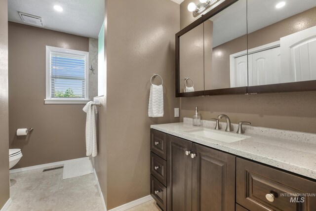 bathroom with vanity, toilet, and baseboards