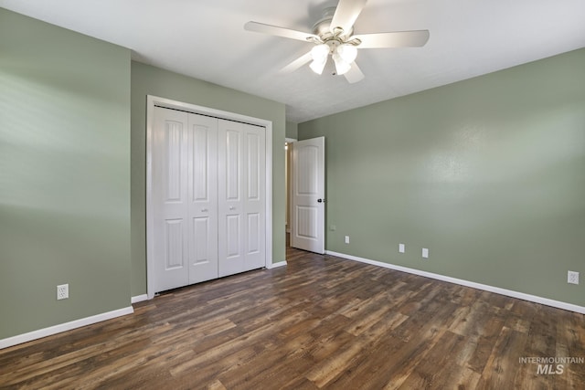 unfurnished bedroom with baseboards and dark wood-style flooring