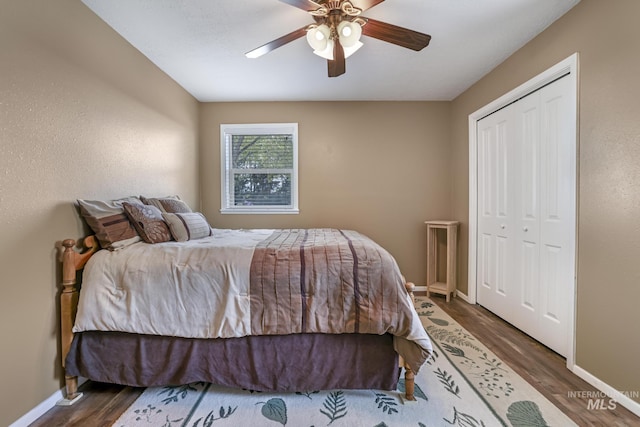 bedroom with wood finished floors, baseboards, a closet, and ceiling fan