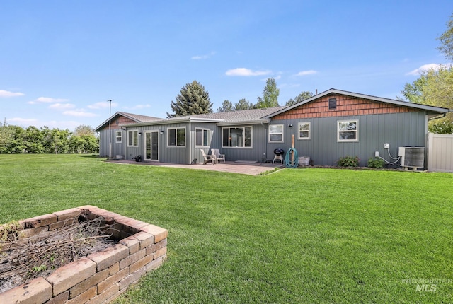 back of house with cooling unit, an outdoor fire pit, a patio, a lawn, and board and batten siding