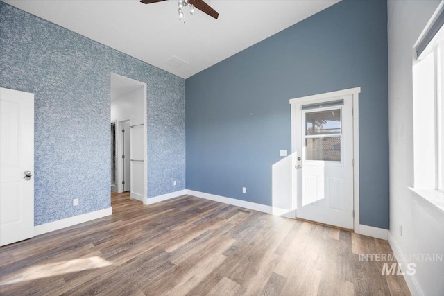 empty room with hardwood / wood-style floors, vaulted ceiling, and ceiling fan