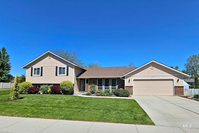 tri-level home with a garage, concrete driveway, and brick siding