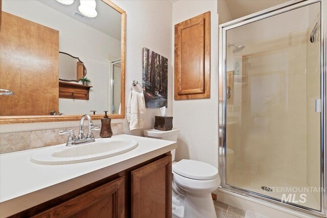 11722 W Jenilyn, Boise, ID 83713 - bathroom featuring a shower stall, toilet, vanity, and tile patterned flooring