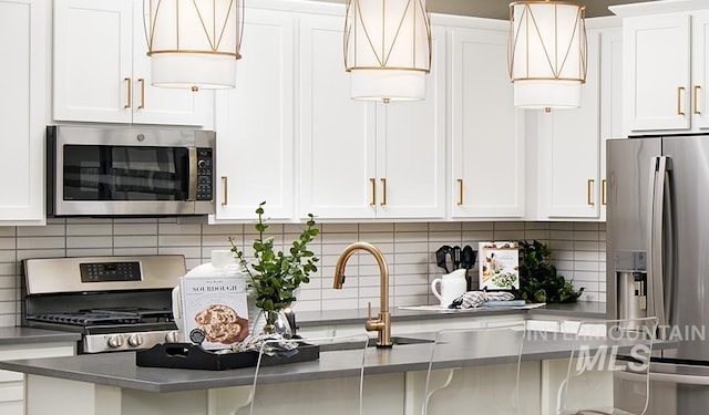 546 Thistle Hills Ave, Middleton, ID 83644 - kitchen featuring white cabinets, a sink, appliances with stainless steel finishes, decorative backsplash, and a breakfast bar area