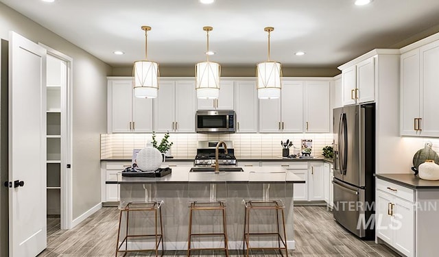 546 Thistle Hills Ave, Middleton, ID 83644 - kitchen with light wood-style floors, appliances with stainless steel finishes, a sink, and dark countertops