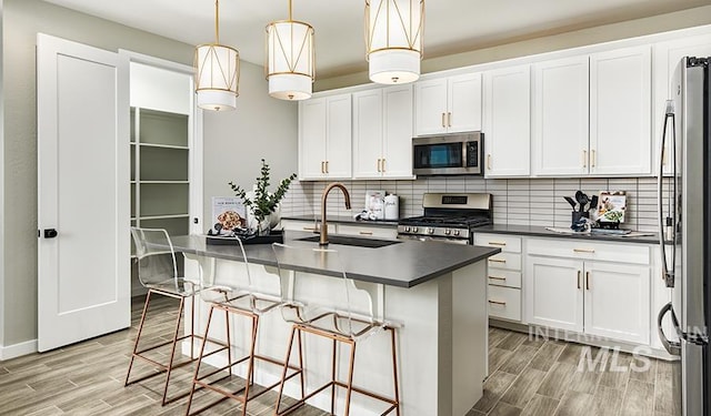 546 Thistle Hills Ave, Middleton, ID 83644 - kitchen featuring a sink, dark countertops, wood tiled floor, stainless steel appliances, and decorative backsplash