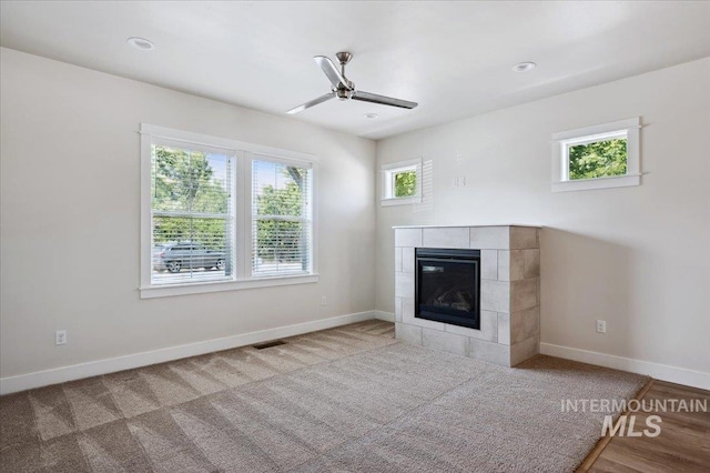 10276 W Utahna Rd, Boise, ID 83714 - unfurnished living room featuring a tile fireplace, ceiling fan, baseboards, and carpet