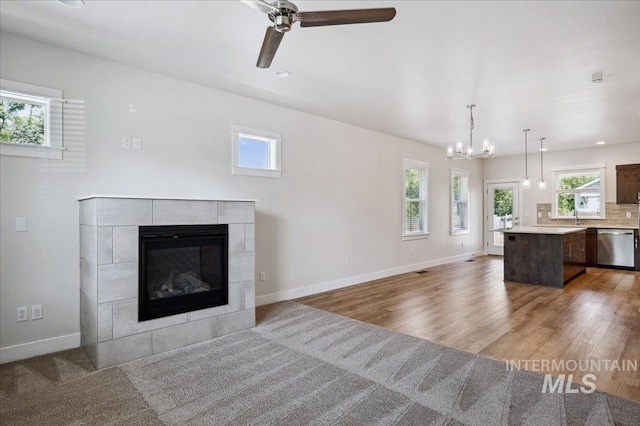 10276 W Utahna Rd, Boise, ID 83714 - unfurnished living room with a fireplace, a ceiling fan, baseboards, a chandelier, and wood finished floors