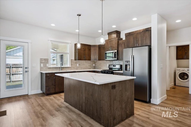 10276 W Utahna Rd, Boise, ID 83714 - kitchen with appliances with stainless steel finishes, washer / dryer, dark brown cabinetry, light wood-style flooring, and recessed lighting