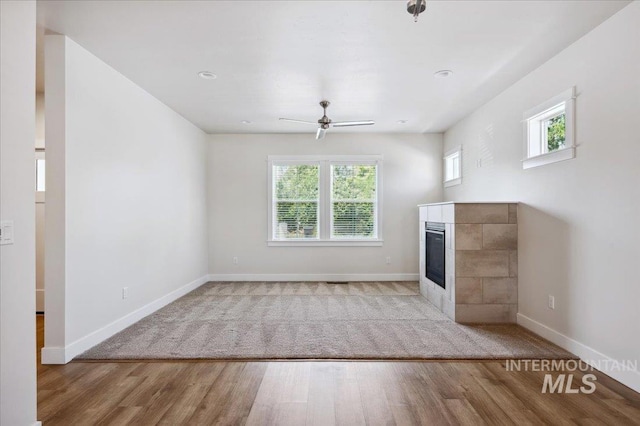 10276 W Utahna Rd, Boise, ID 83714 - unfurnished living room with light wood-style floors, a ceiling fan, baseboards, and a fireplace