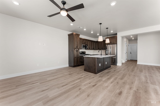 202 S Koyukuk Ln, Star, ID 83669 - kitchen featuring appliances with stainless steel finishes, open floor plan, light countertops, recessed lighting, and dark brown cabinetry