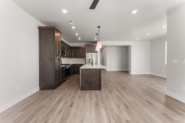 202 S Koyukuk Ln, Star, ID 83669 - kitchen with stainless steel appliances, light countertops, baseboards, dark brown cabinetry, and decorative light fixtures