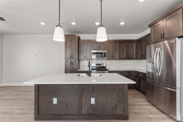 202 S Koyukuk Ln, Star, ID 83669 - kitchen featuring appliances with stainless steel finishes, a sink, dark brown cabinetry, tasteful backsplash, and light countertops