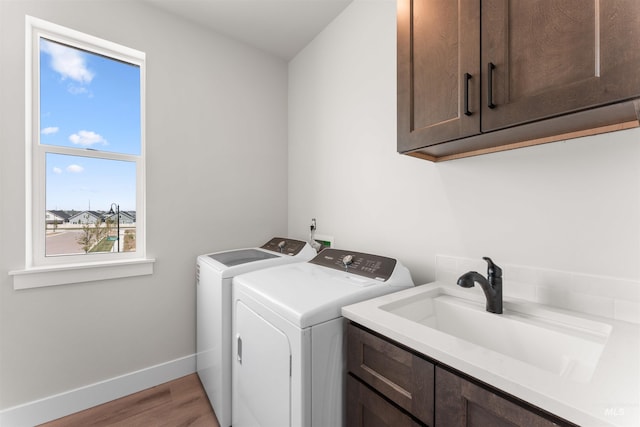 202 S Koyukuk Ln, Star, ID 83669 - laundry area featuring cabinet space, separate washer and dryer, light wood finished floors, and baseboards